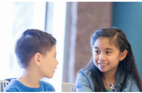 Boy and girl student partners talking.