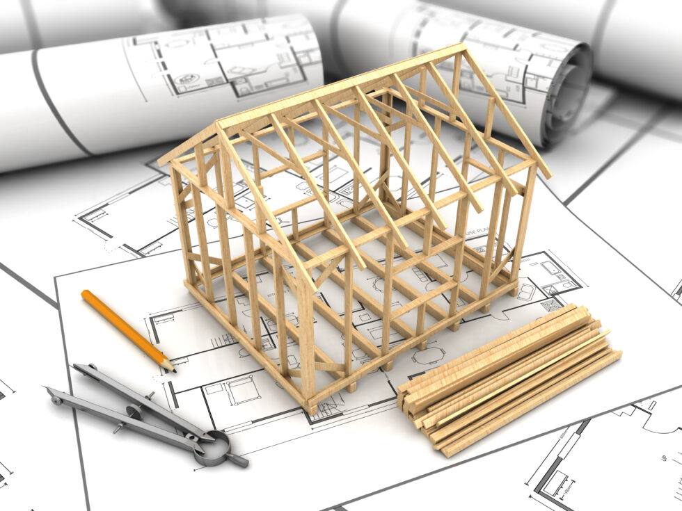 House frame of sticks on top of architecture plan.