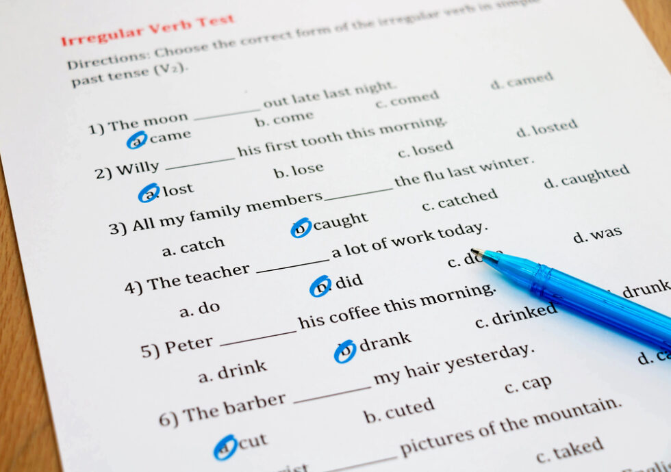 Image shows fill in the blank sentence activities on paper for grammar exercises with blue pen.