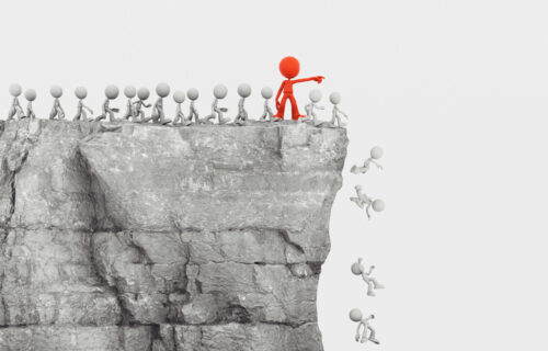 Red leader pointing small white figures off a cliff illustrates that following literacy trends can lead to confusion and ineffective results.